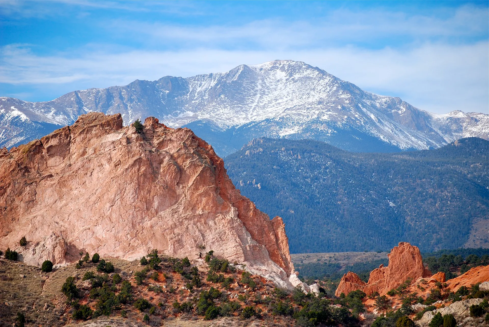 Snow-capped Pikes Peak rising behind the red rock formations of Garden of the Gods